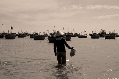 Rear view of man on sea against sky