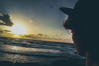 Silhouette man at beach against sky during sunset