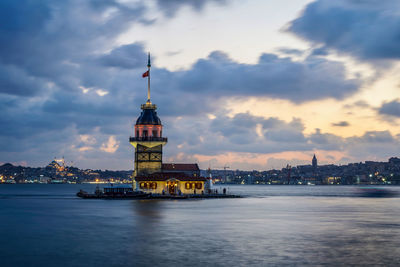 M. tower amidst buildings against sky at dusk