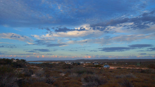 Scenic view of field against cloudy sky