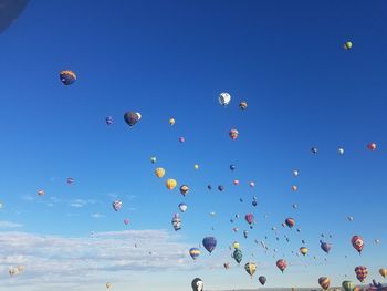 Low angle view of hot air balloons against blue sky