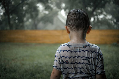 Side view of boy looking away while standing outdoors
