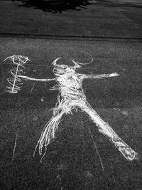 Chalk drawing of devil on asphalt