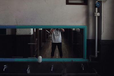 Full length portrait of man standing on railroad station