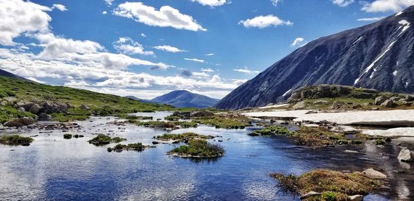 Scenic view of river and mountains against sky