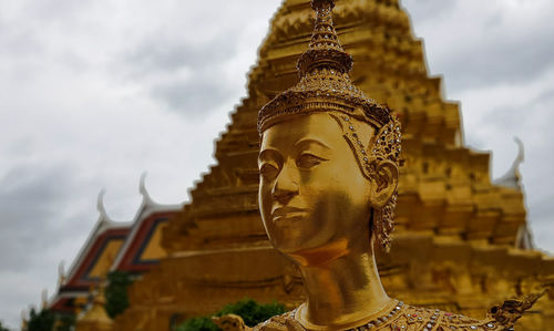 Low angle view of statue against temple building