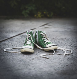 Close-up of green shoes on footpath