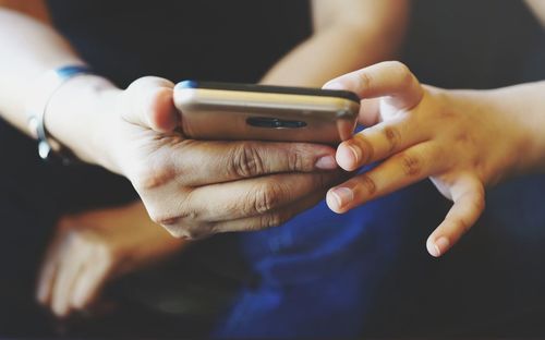 Midsection of man using mobile phone