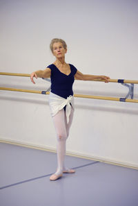 Full length of woman standing against wall