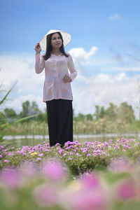 Full length of woman standing on purple flowering plants