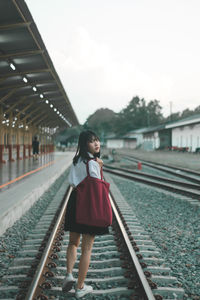 Full length of woman standing on railroad station platform