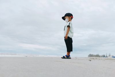 Full length of man standing on beach against sky