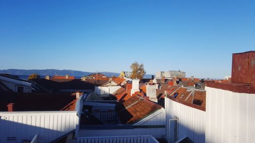 High angle view of houses against clear blue sky