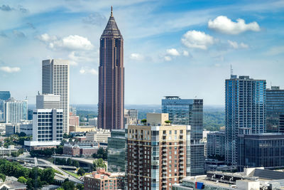 Skyscrapers in city against cloudy sky