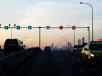 Cars on road against sky in city