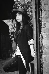 Portrait of young woman standing by pipe