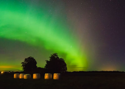 Scenic view of illuminated field against sky at night