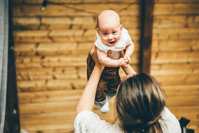 High angle view of cute baby girl standing against wall