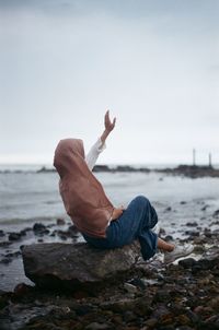 Low section of man walking on beach against sky