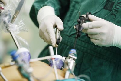 Midsection of doctor operating on patient in operating room