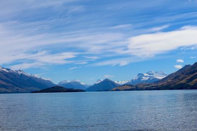 Scenic view of lake by snowcapped mountains against sky