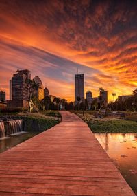 River amidst buildings against sky during sunset