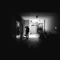 Rear view of silhouette man and woman walking in corridor