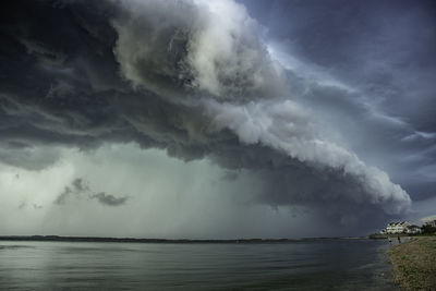 Scenic view of sea against storm clouds