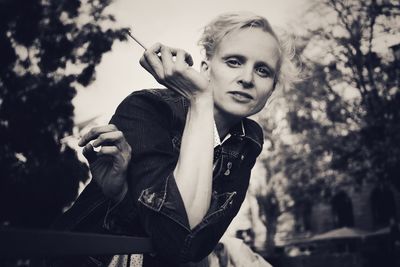 Portrait of young woman holding cigarette