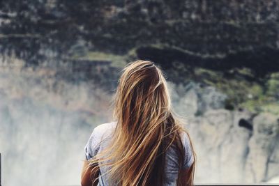 Rear view of woman standing against blurred background