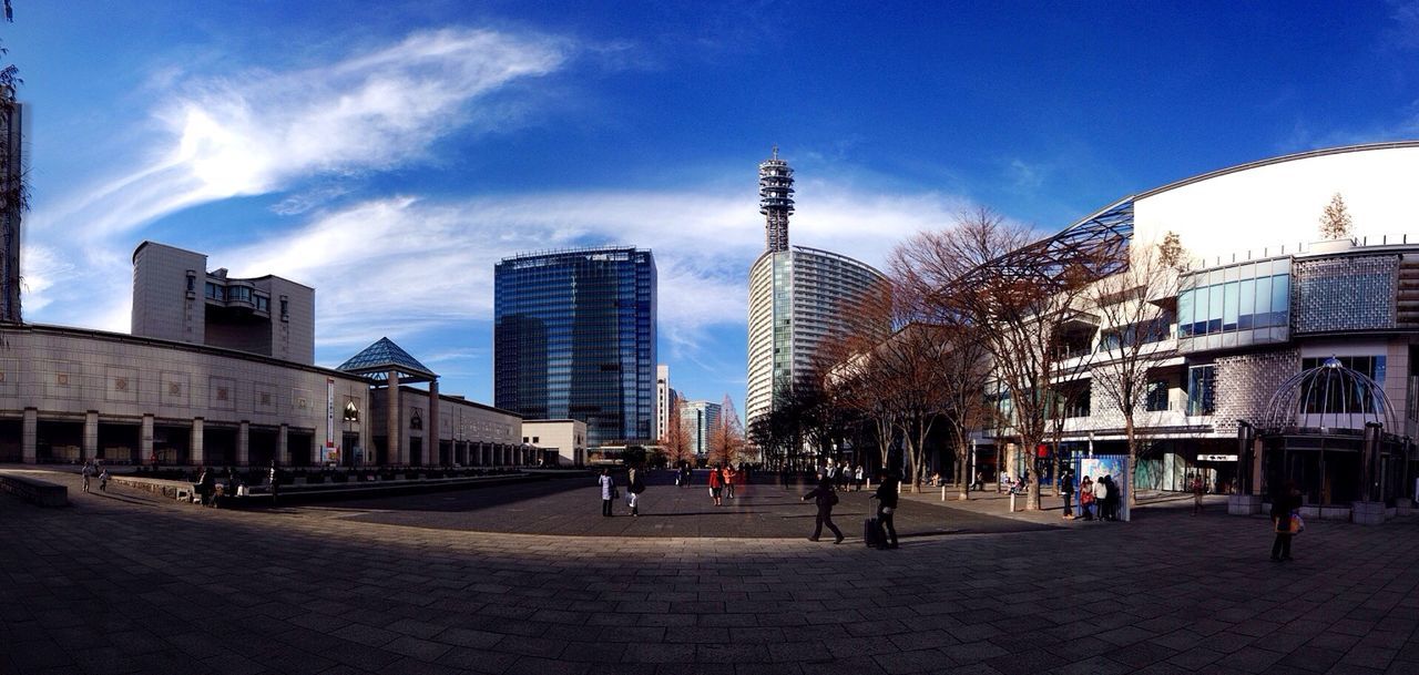 building exterior, architecture, built structure, sky, city, cloud - sky, city life, building, large group of people, blue, cloud, modern, incidental people, day, street, sunlight, outdoors, travel destinations, office building