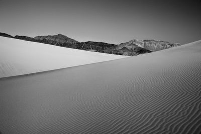 Sand dunes against clear sky