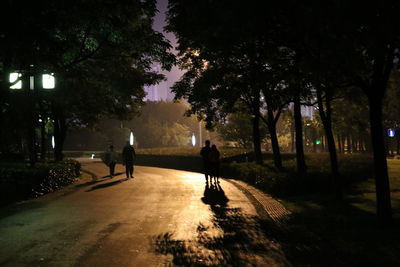 People on sidewalk in city at night