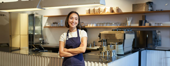 Portrait of young woman standing in kitchen