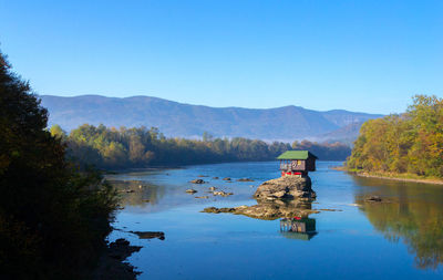 Scenic view of lake against clear blue sky