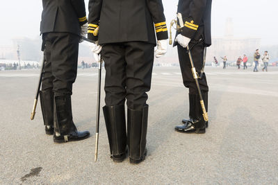 Low section of soldiers standing on street in city