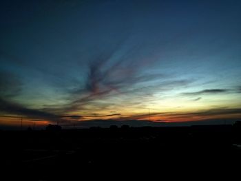 Silhouette landscape against dramatic sky during sunset