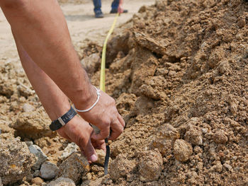 Cropped hands measuring at construction site