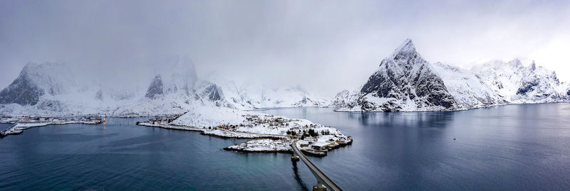 Scenic view of lake by snowcapped mountain against sky