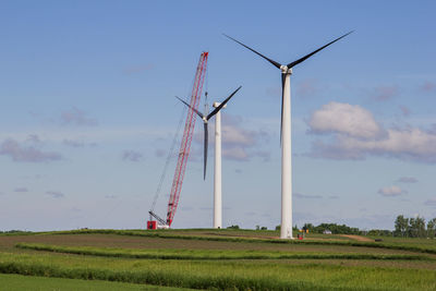 Windmill on field against sky