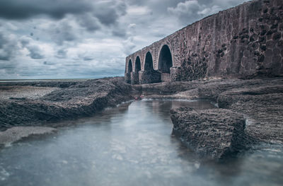 View of arch bridge over river against sky