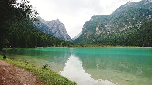 Scenic view of lake by mountains against sky