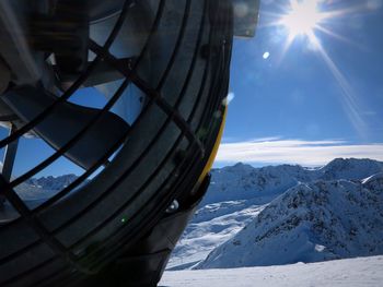 Cropped image of machine against snowcapped mountains