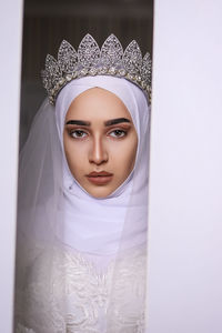 Portrait of young bride looking away through door