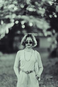 Portrait of young woman wearing sunglasses standing outdoors