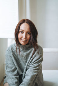 Portrait of young woman sitting at home