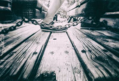 Low section of people standing on wooden plank