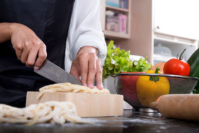Close-up of man preparing food on cutting board