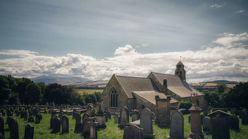 Panoramic view of cemetery and buildings against sky