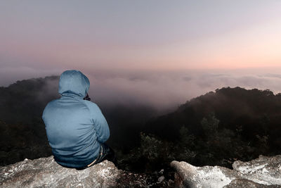 Man sitting and watching the view on the mountain. he was happy and happy.